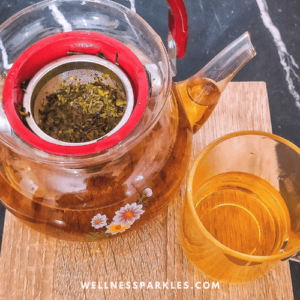 tea pot with oregano and olive tree leaves tea and a cup