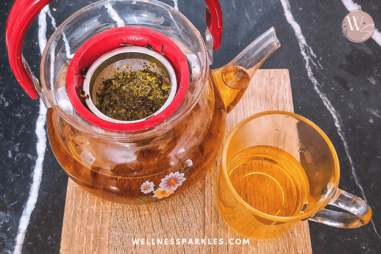 tea pot with oregano and olive tree leaves tea and a cup